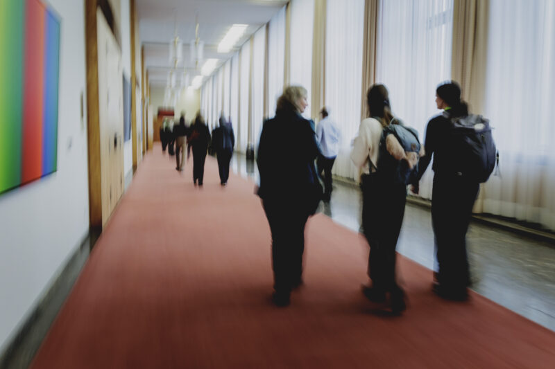 Blurry image of the backs of three women walking in the conference halls